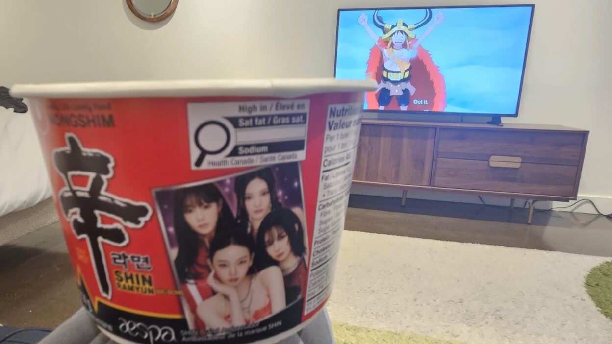 Enjoying an aespa Shin Ramyun bowl in my hotel room while watching One Piece